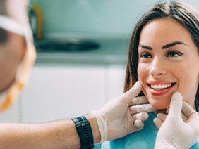 Smiling woman in dental chair with porcelain dental crowns in Oklahoma City