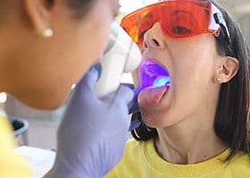 Woman receiving oral cancer screening from dentist