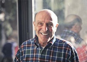 older man smiling in plaid shirt