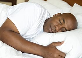 Man sleeping in bed on his side