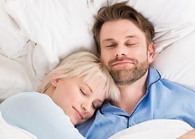 Man and woman sleeping soundly in bed