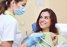 Smiling female dental patient getting a dental crown 