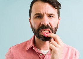 bearded man looking at his gums 