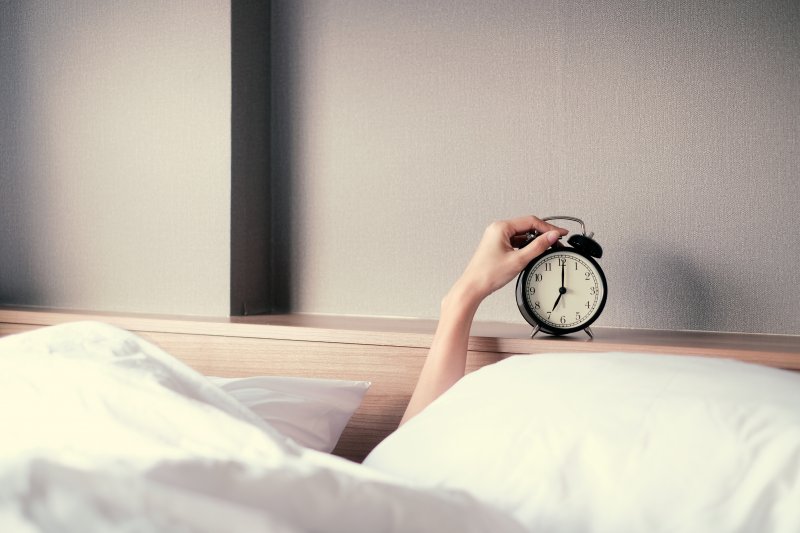 person waking up with old-timey clock